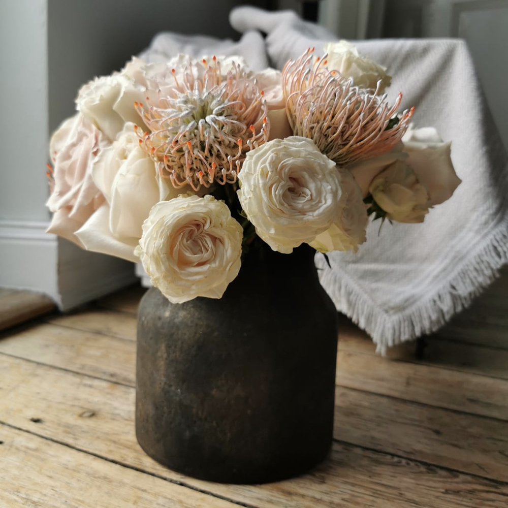 Protea und Rosen in einer Vase